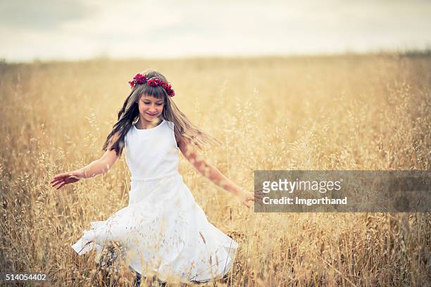 little girl dancing in grain field - avena stock pictures, royalty-free photos & images