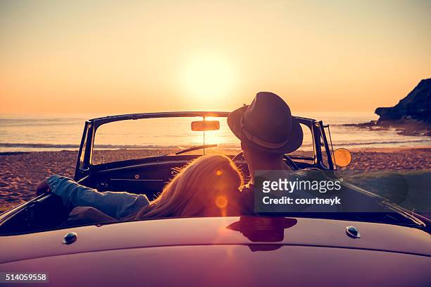 paar beobachten den sonnenuntergang in einem cabrio auto. - sunset stock-fotos und bilder