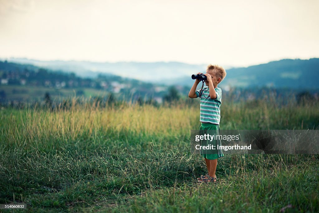 Little hiker looking at view with binoculars