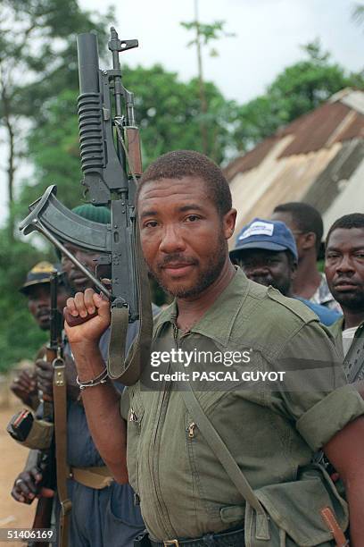 Rebel leader Charles Taylor holds his Soviet-made AK-47 assault rifle in Buchanan 29 May 1990 as he continues his march on the capital Monrovia to...