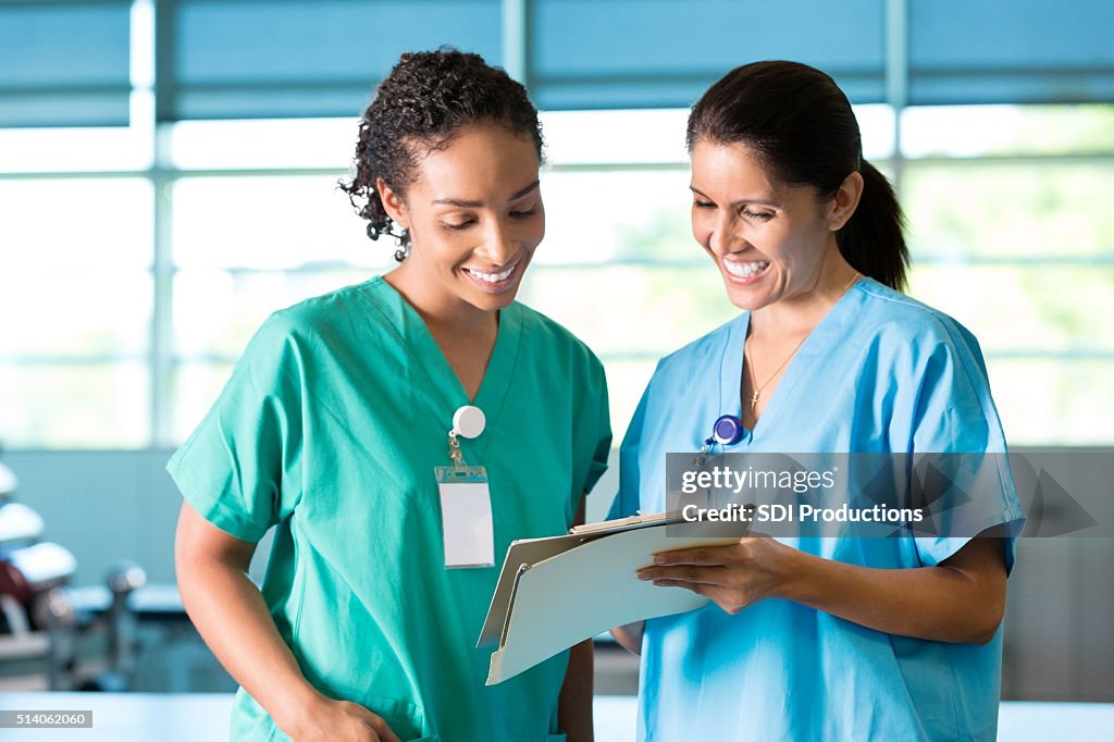 Nurses or physical therapists discuss patient