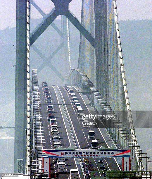 Vehicles cross the 3,911-meter-long Akashi Kaikyo Bridge, the world's longest suspension bridge, to mark its opening to traffic between Kobe and...