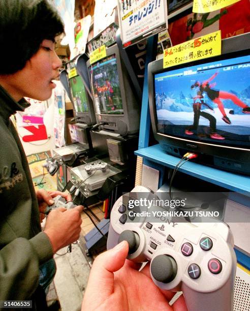 Teenager plays a video game on Sony's Playstation machine at a computer shop in Tokyo's Akihabara electronic shops district 08 May. Japanese...
