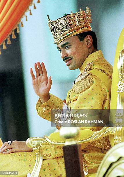 Prince Al-Muhtadee Billah, 24 year-old heir to the throne of Brunei, waves to the crowd during a procession in the town of Bandar Seri Begawan after...