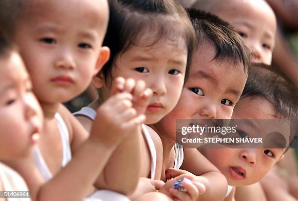 Group of Chinese children gather at a park in Beijing 29 July 1999. Two decades of China's state-imposed "one-child policy" has given way to more...