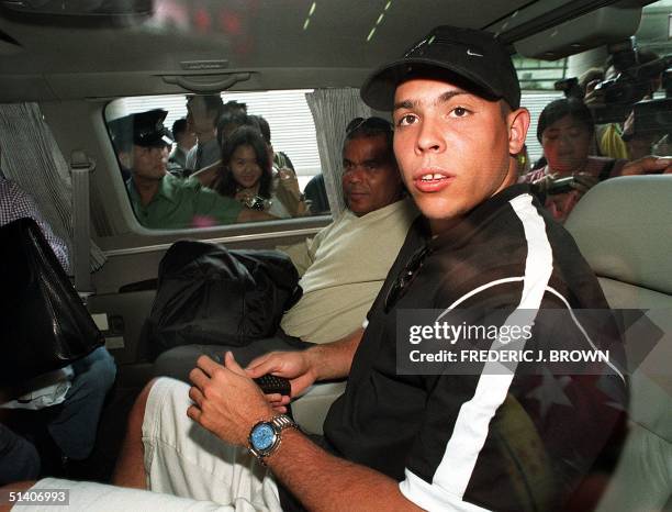 Brazilian soccer star Ronaldo looks out from inside of his minivan, 07 August 1999, upon arrival in Hong Kong, as police attempt to keep fans and...