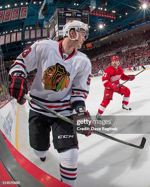 Brandon Mashinter of the Chicago Blackhawks skates in the corner in front of Tomas Tatar of the Detroit Red Wings during an NHL game at Joe Louis...