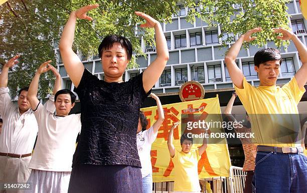 Falun Gong adherents practice breathing and meditation exercises during a protest outside the Central Government Offices 29 October 1999 in Hong...