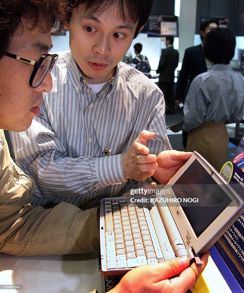 A staff of Japan's NEC introduces its new personal