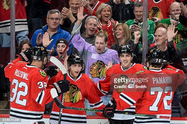 Patrick Kane of the Chicago Blackhawks celebrates with Michal Rozsival, Trevor van Riemsdyk and Artemi Panarin after scoring in the first period of...