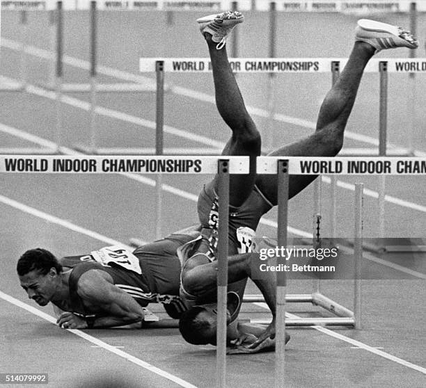 Greg Foster winds up upside down after a collision with Mark McKoy duirng finals of 60m hurdles at world Indoor Championships in track & field in...