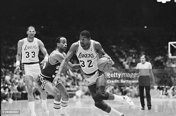 Magic Johnson of the Los Angeles Lakers dribbles the basketball past Darrell Griffith of the Utah Jazz in a NBA game at the Forum. Inglewood,...