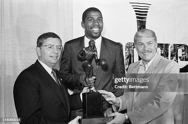 Flanked by NBA commissioner David Stern and Los Angeles Lakers' owner Jerry Buss, Magic Johnson holds the NBA Most Valuable Player trophy for the...