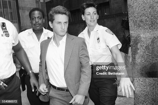 Three court officers escort actor Sean Penn to his arraignment on charges of attacking a New York Post photographer's car.