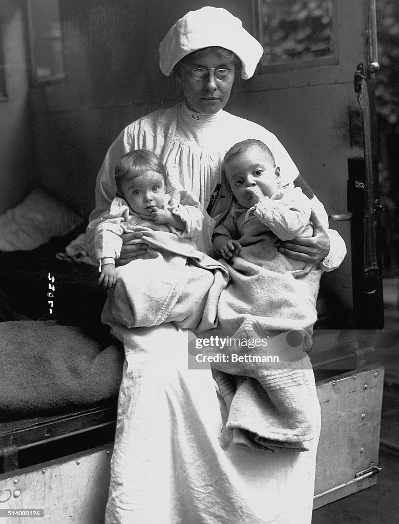 Nurse Holding Two Infants