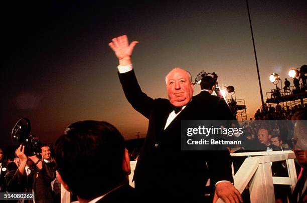 Alfred Hitchcock waves to the crowds upon his arrival at the Academy Awards Ceremony of 1968.