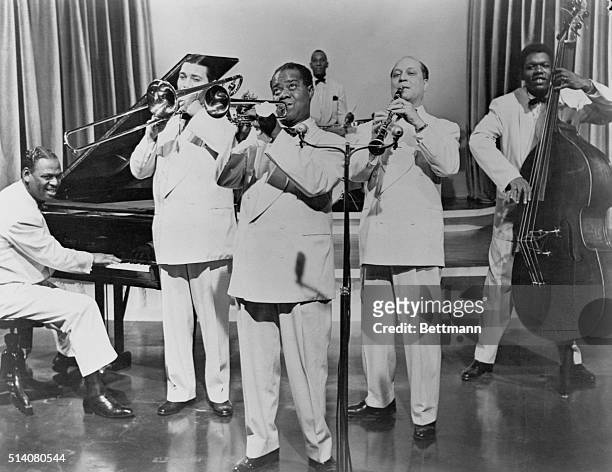 Jazz musician Louis Armstrong performing with his band. Undated photograph.