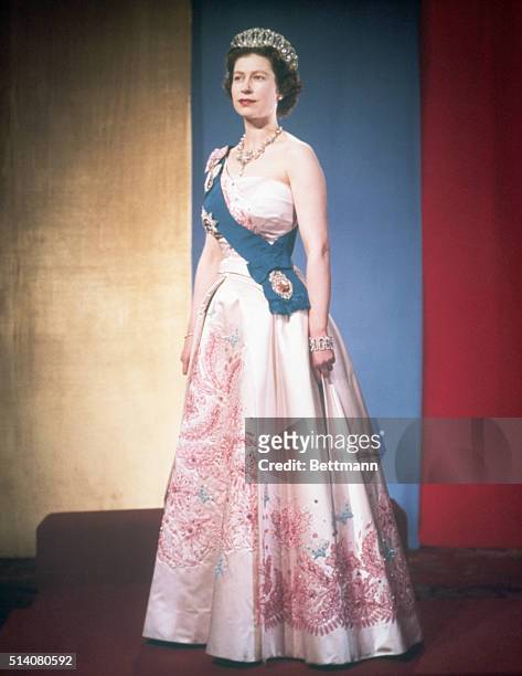 Queen Elizabeth II, dressed for a formal occasion. She wears her family's orders and orders of her kingdom on the sash over her shoulder, and several...