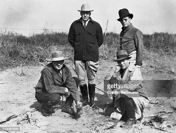 Planting the first tree in the National Shelterbelt project is Oklahoma state forester George H. Phillips. Crouching at his side is Wilson Martin,...