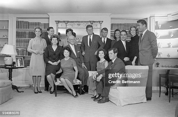 President-elect John F. Kennedy stands at the center of his large family in the living room of his father's home in Hyannisport. Standing by him are:...