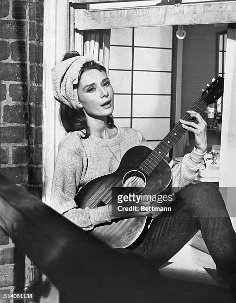 Audrey Hepburn playing guitar