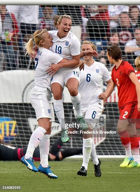 Toni Duggan of England celebrates with teammate Katie Chapman after scoring a goal against Germany during the first half of a friendly international...