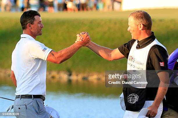 Adam Scott of Australia celebrates with his caddie David Clark after holing his winning putt on the par 4, 18th hole during the final round of the...
