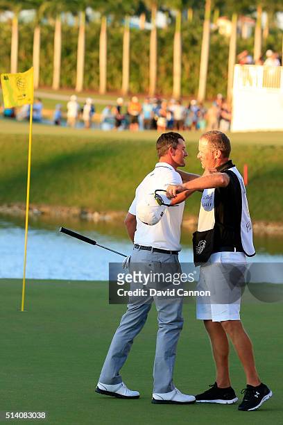 Adam Scott of Australia celebrates with his caddie David Clark after holing his winning putt on the par 4, 18th hole during the final round of the...