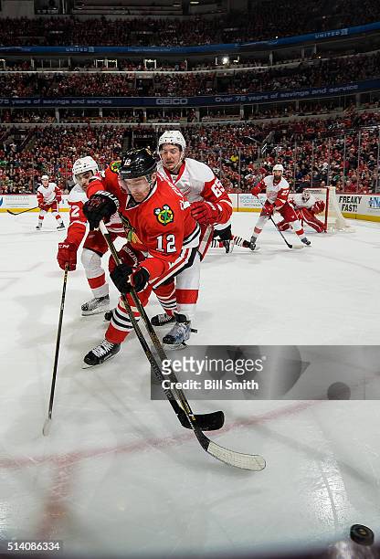 Tomas Fleischmann of the Chicago Blackhawks chases the puck against Andreas Athanasiou and Danny DeKeyser of the Detroit Red Wings in the third...