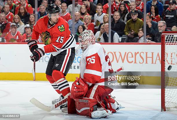 Artem Anisimov of the Chicago Blackhawks scores on goalie Jimmy Howard of the Detroit Red Wings in the third period of the NHL game at the United...