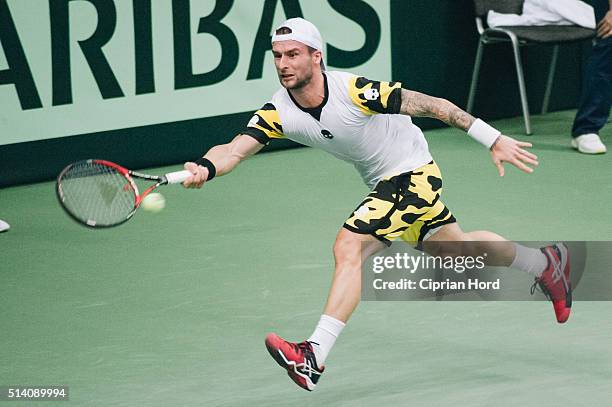 Adrian Ungur of Romania in action against Grega Zemlja of Slovenia during day 1 of the Davis Cup World Group first round tie between Romania and...