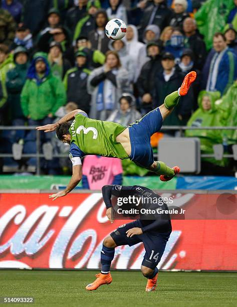 Brad Evans of the Seattle Sounders FC tumbles over Dom Dwyer of Sporting Kansas City at CenturyLink Field on March 6, 2016 in Seattle, Washington....