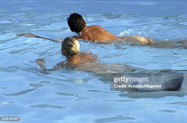 Actress Brigitte Nielsen is seen swimming naked with her fiance Mattia Dessi at a public pool on August 12, 2004 in Milano Marittima, Italy.