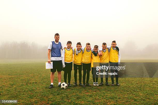 portrait of kids team with coach after playing soccer - youth sports competition stock pictures, royalty-free photos & images