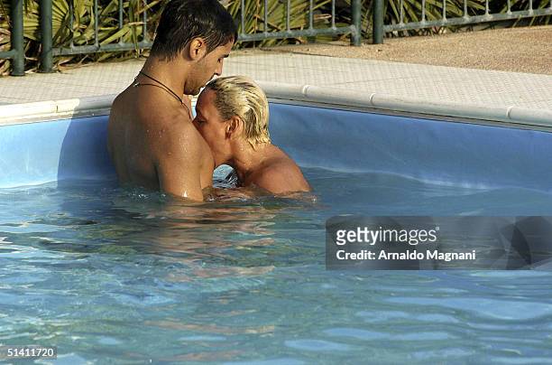 Actress Brigitte Nielsen is seen swimming naked with her fiance Mattia Dessi at a public pool on August 12, 2004 in Milano Marittima, Italy.