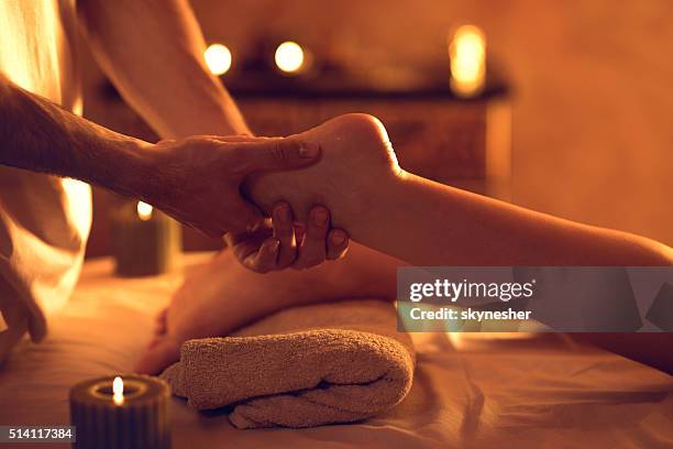 donna irriconoscibile massaggiatore massaggio piedi alla centro benessere. - man touching womans leg foto e immagini stock
