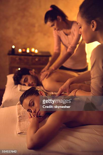 pareja disfrutando de respaldo relajado durante una sesión de masajes en el spa. - black massage therapist fotografías e imágenes de stock