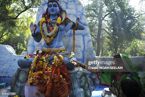 Indian Hindu devotees offer prayers to a statue of the Hindu god Lord Shiva to mark the Maha Shivaratri festival at the Lord Shiva Temple in...