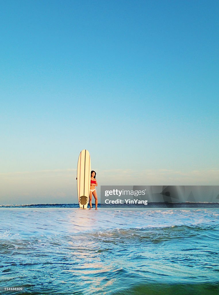 Suefer Girl with Surfboard at Sunset