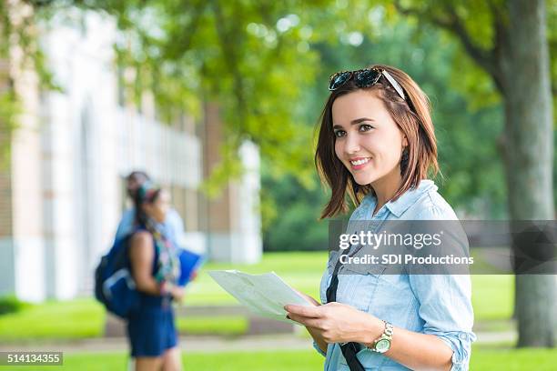 happy college student using campus man while walking to class - college visit stock pictures, royalty-free photos & images