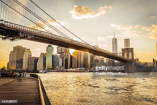 brooklyn bridge and manhattan at sunset - brooklyn new york stockfoto's en -beelden