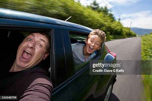 excited father & son travelling in car - irish family stock-fotos und bilder