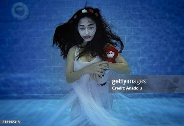 Model performs underwater protest, acting as a woman who exposed to violence, to point out violence to women within a project called "Together...