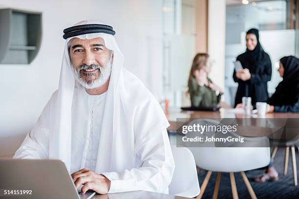 mature arab businessman wearing ghutra using laptop, portrait - hot desking stock pictures, royalty-free photos & images