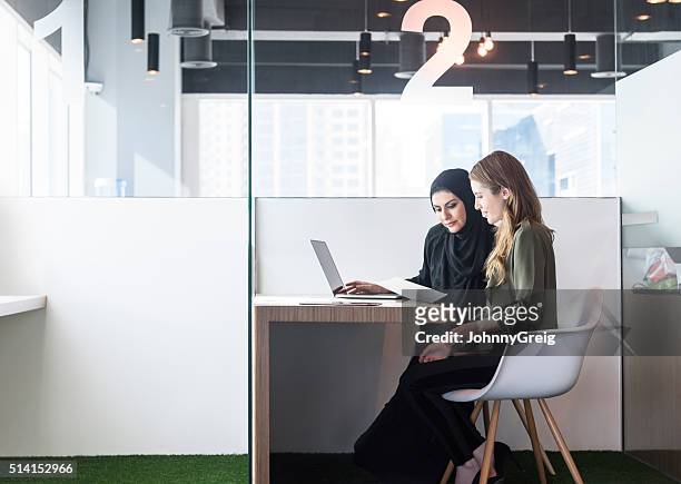 due donne di affari in ufficio cabina, dubai, emirati arabi uniti - emirati arabi uniti foto e immagini stock