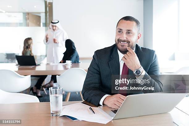 mature arab businessman using laptop in modern office, portrait - managing director office stock pictures, royalty-free photos & images