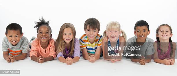 happy kids lying in a row - kids smiling multiple nationalities stock pictures, royalty-free photos & images