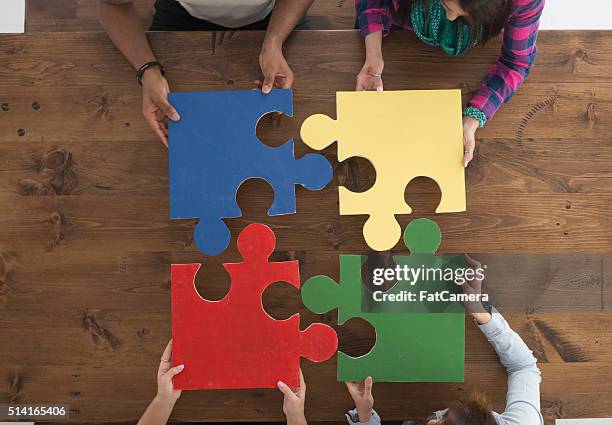 holding puzzle pieces - jigsaw piece stockfoto's en -beelden