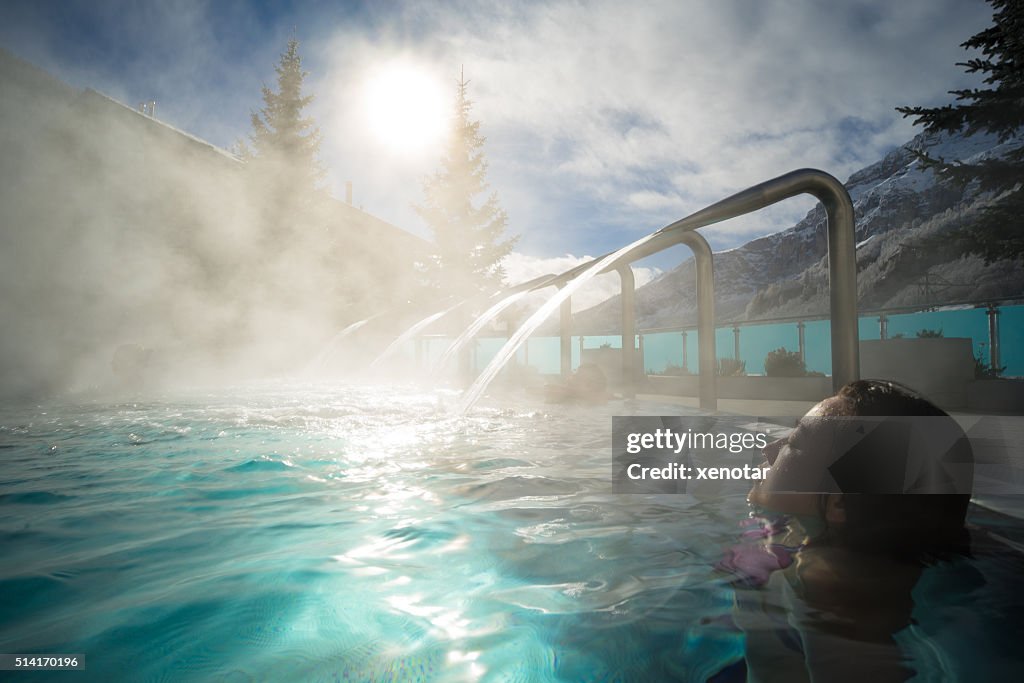 Young Asia woman enjoy hot spring under sunshine