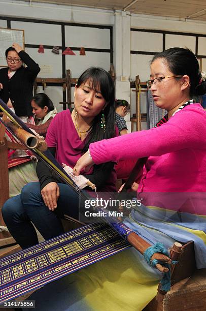 Karma Sonam with a weaver working on handloom at the directorate of Handicraft and Handloom office on March 11, 2015 in Gangtok, India. Karma Sonam...